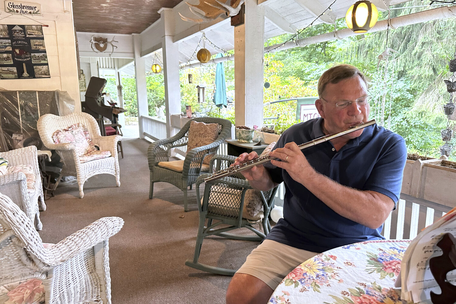 Retired cardiologist Dr. Joe Bering teaches himself flute on the front porch of his cottage in the ...