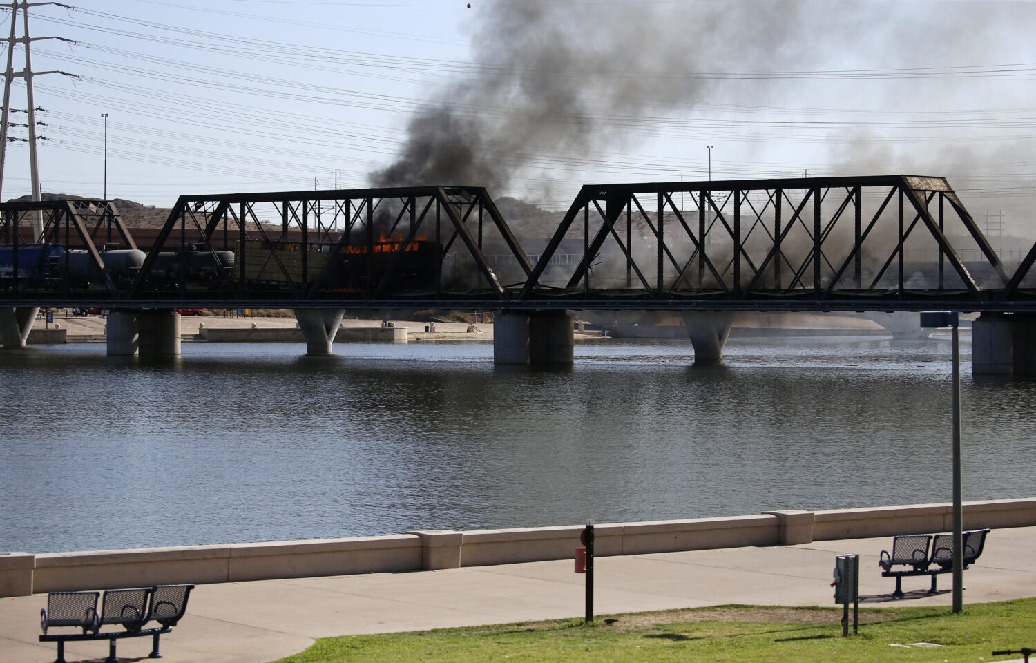 FILE - A derailed freight train burns on a bridge spanning Tempe Town Lake, July 29, 2020, in Tempe...