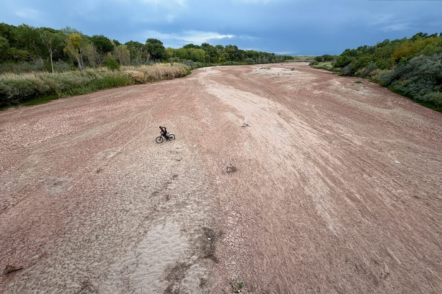 A bicyclist traverses the Rio Grande's dry riverbed in Albuquerque, N.M., on Thursday, Aug. 21, 202...