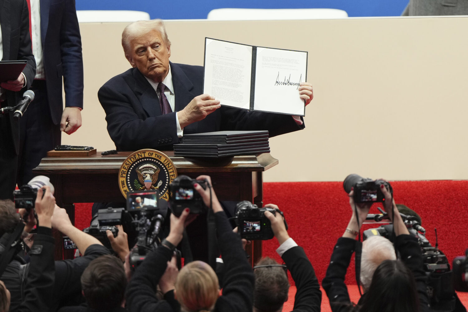 FILE - President Donald Trump holds up an executive order after signing it at an indoor Presidentia...