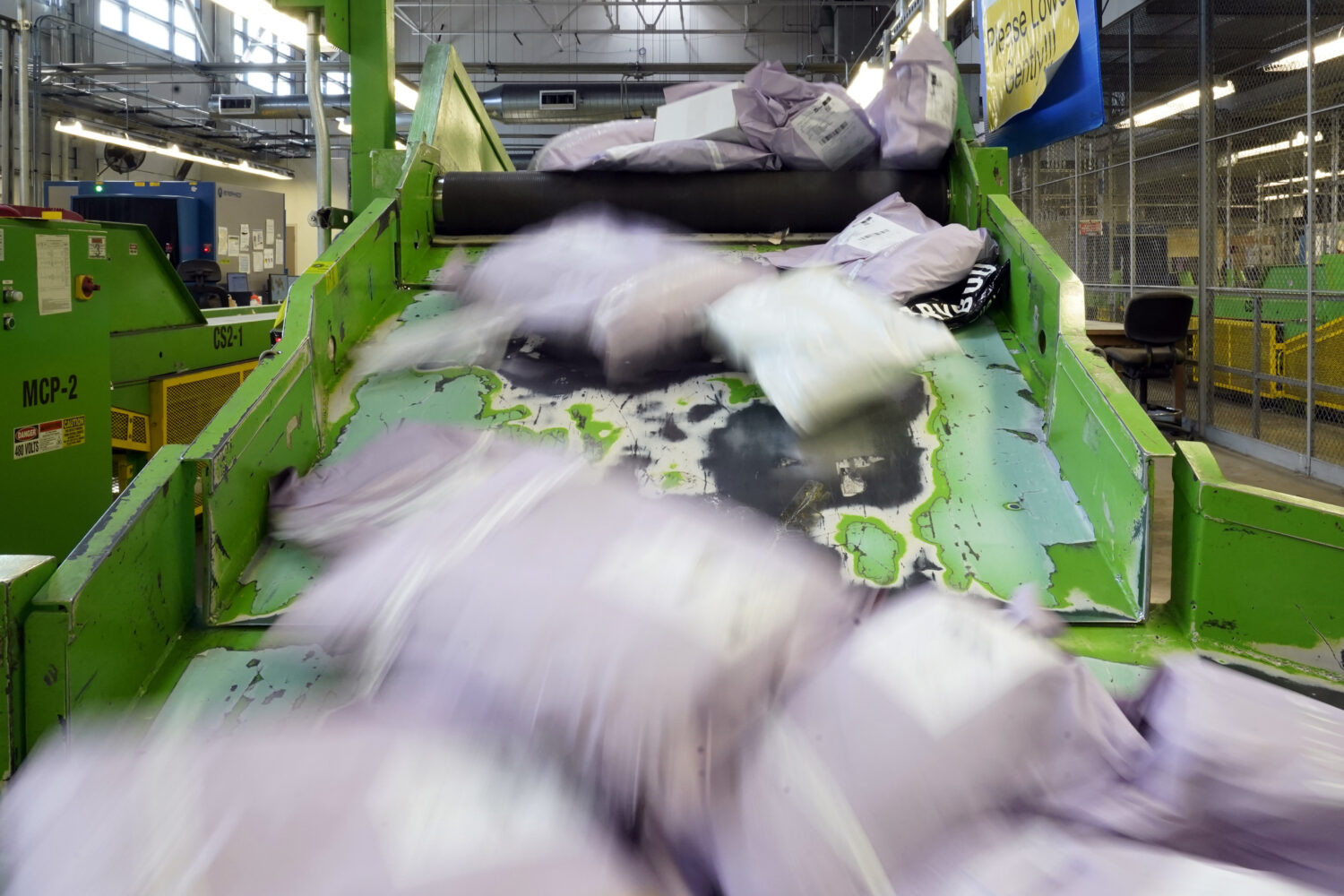 FILE - Parcels slide down a ramp after being scanned at the U.S. Customs and Border Protection over...