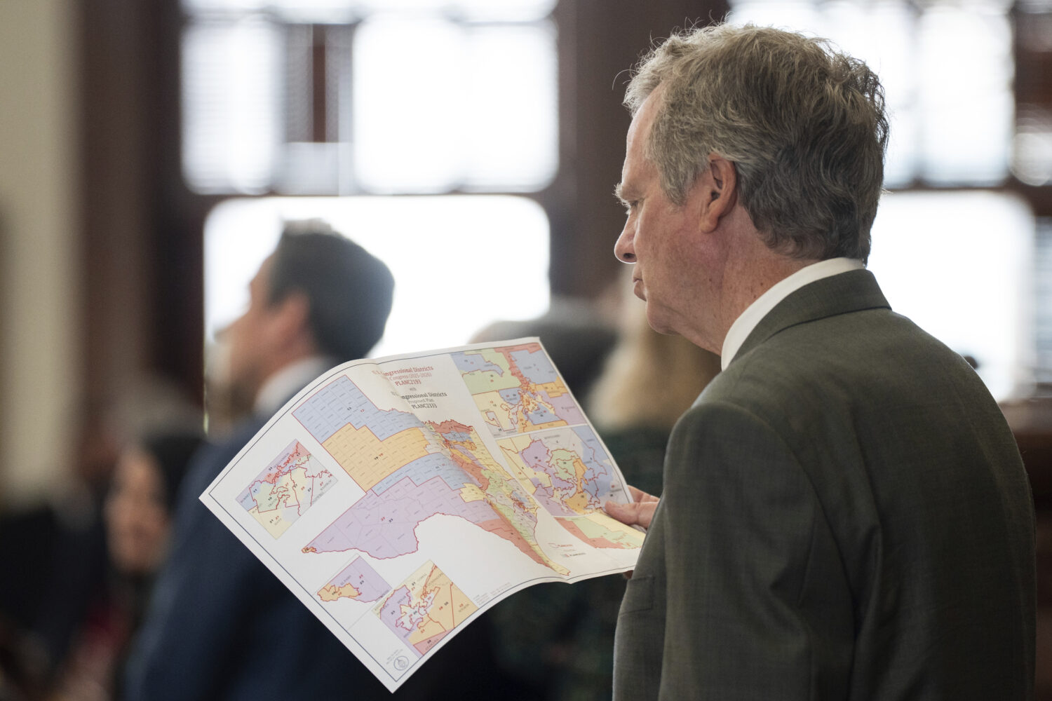 Rep. Mike Olcott, R-Fort Worth, looks at a redrawn congressional district map as its proposal is de...