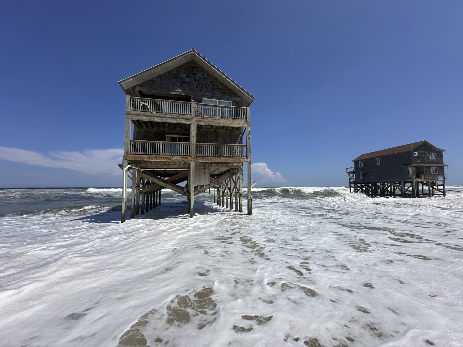 Two houses sit out in the heavy surf as Hurricane Erin passes offshore at Rodanthe, N.C., on Tuesda...