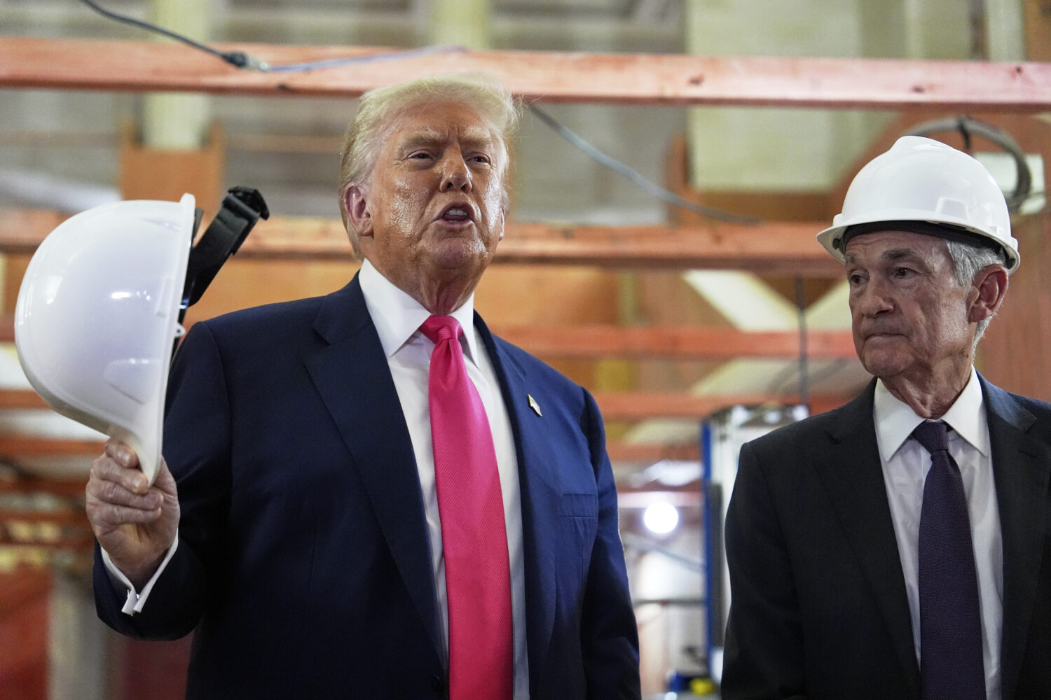 President Donald Trump speaks as Federal Reserve Chairman Jerome Powell listens during a visit to t...