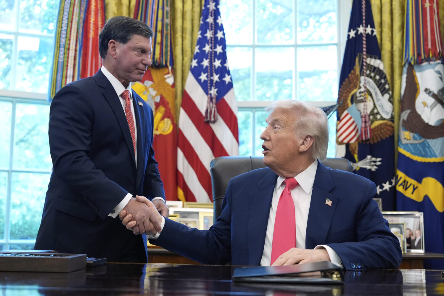 President Donald Trump, right, shakes the hand of Social Security Commissioner Frank Bisignano duri...