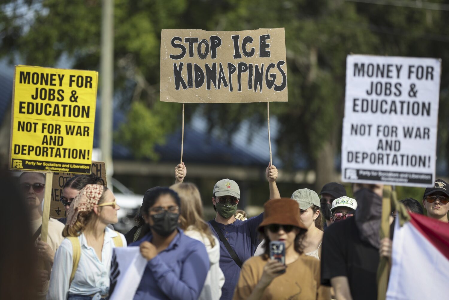 FILE - Demonstrators hold signs during an immigration rally near the Pinellas County Jail in Clearw...