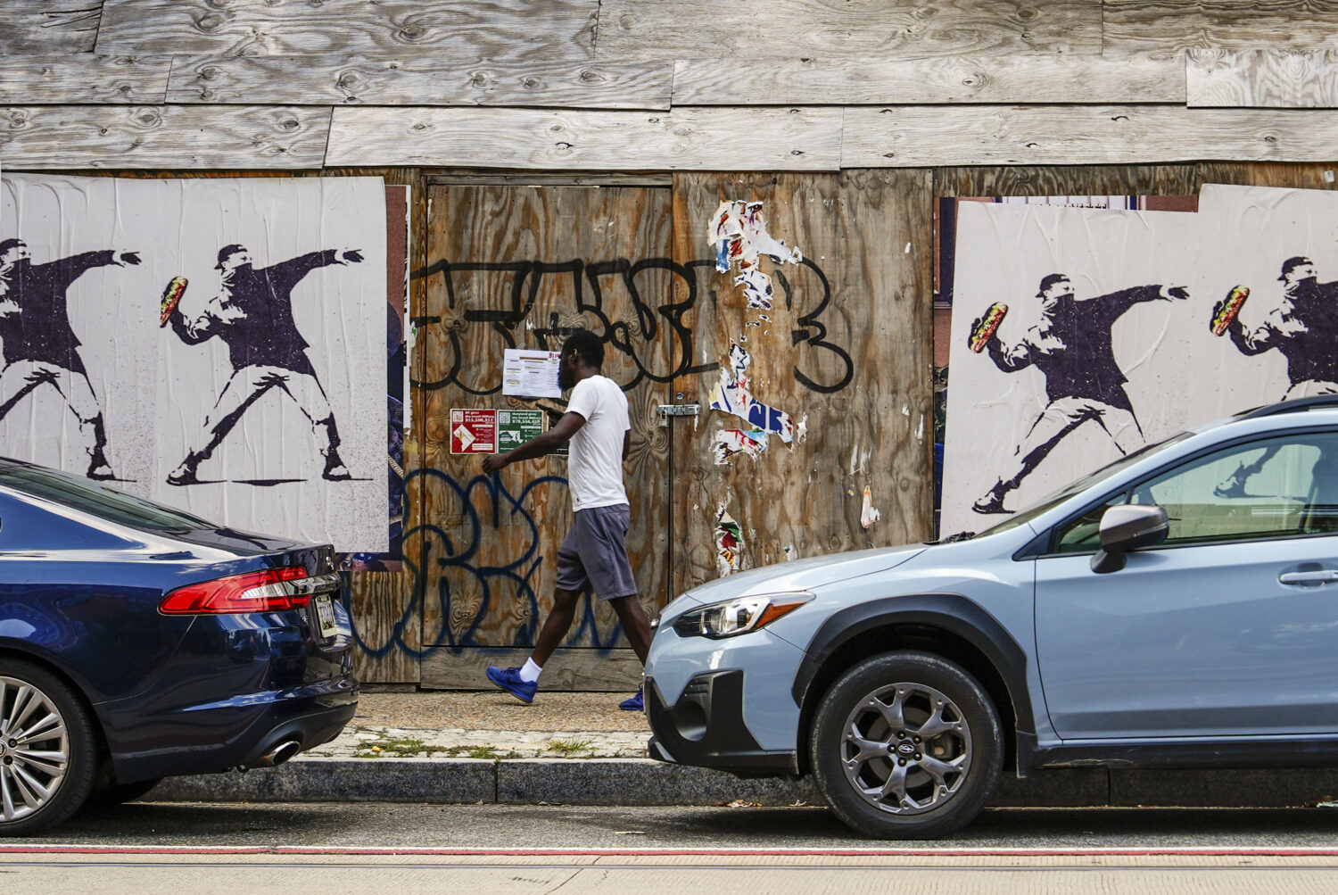 Posters of a person throwing a sandwich are pictured along H Street, Sunday, Aug. 17, 2025, in Wash...