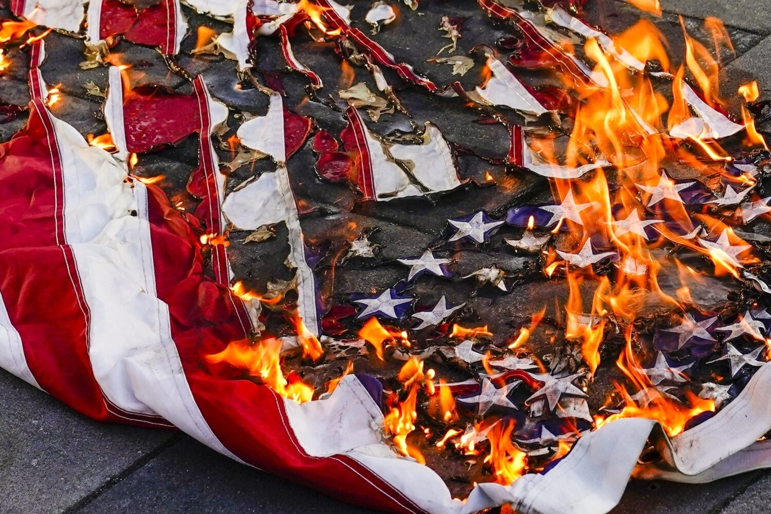FILE - An American flag is burned during a march for Jayland Walker, July 6, 2022, in New York. (AP...