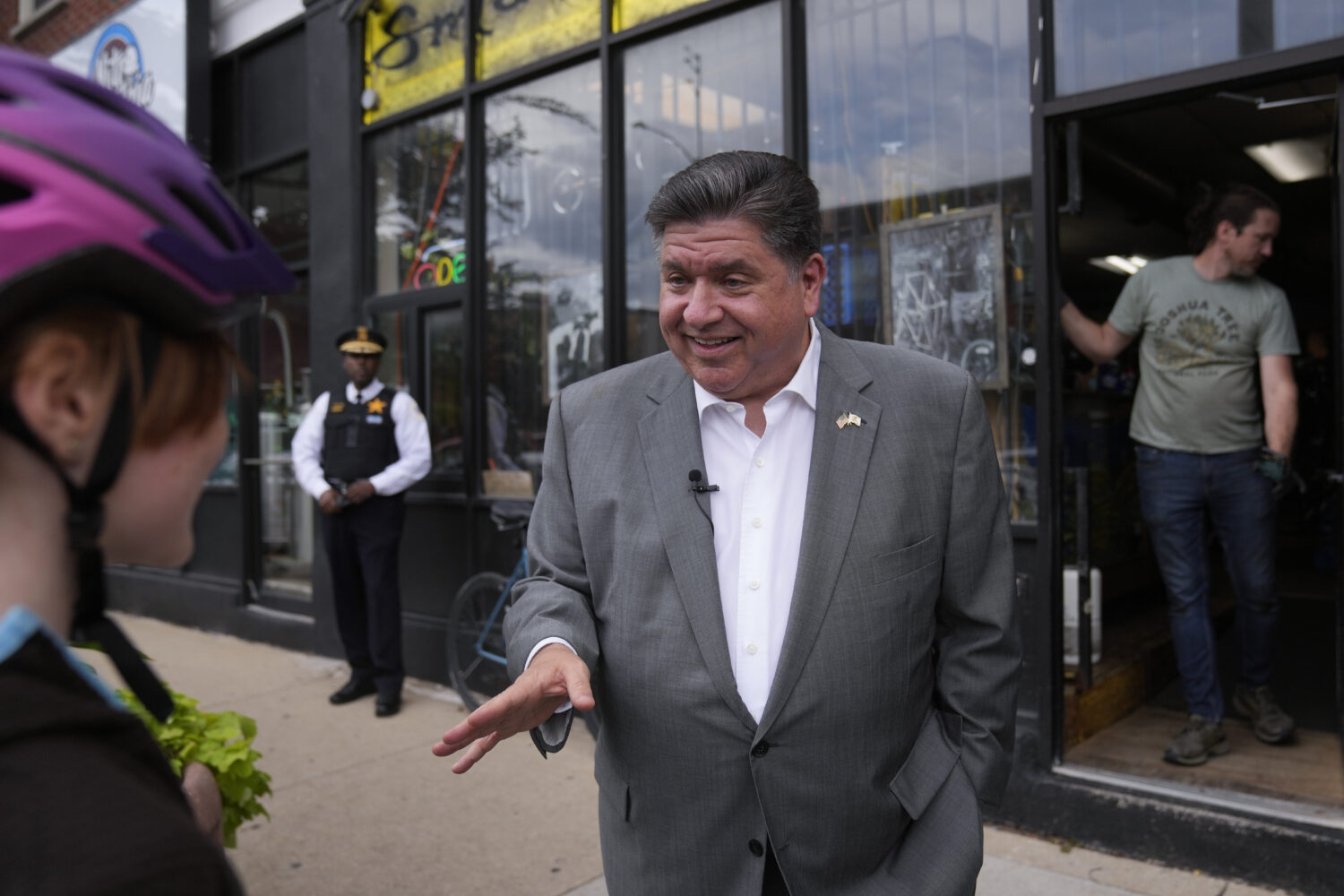 Illinois Gov. J.B. Pritzker talks to people outside of Small Shop Cycles & Service, Wednesday, Aug....