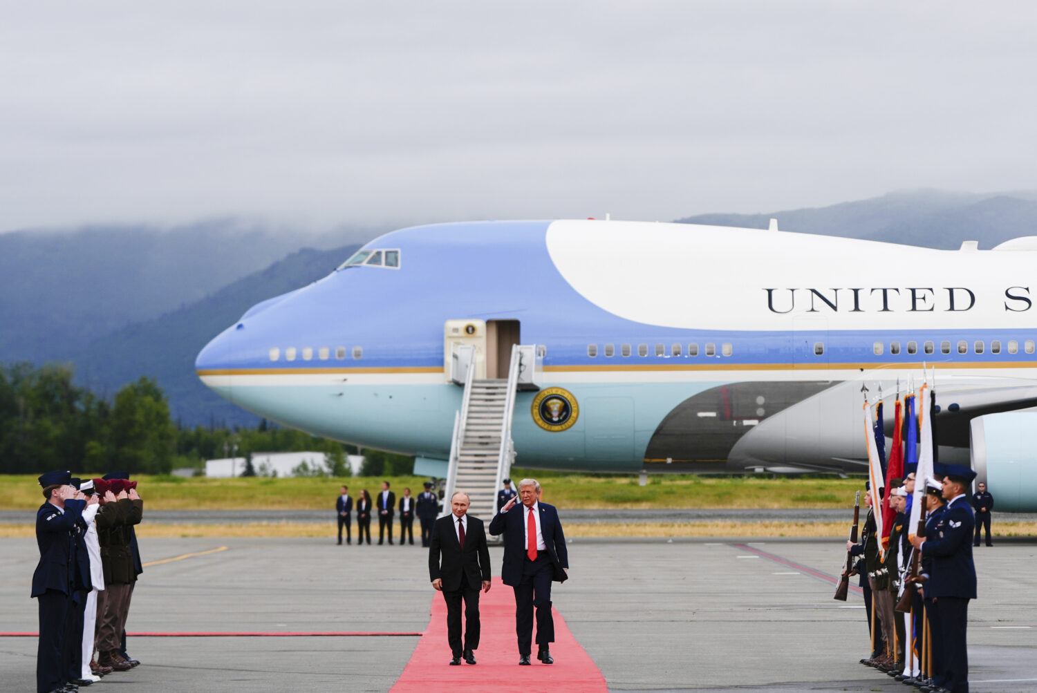 President Donald Trump salutes as he walks Russia's President Vladimir Putin, Friday, Aug. 15, 2025...