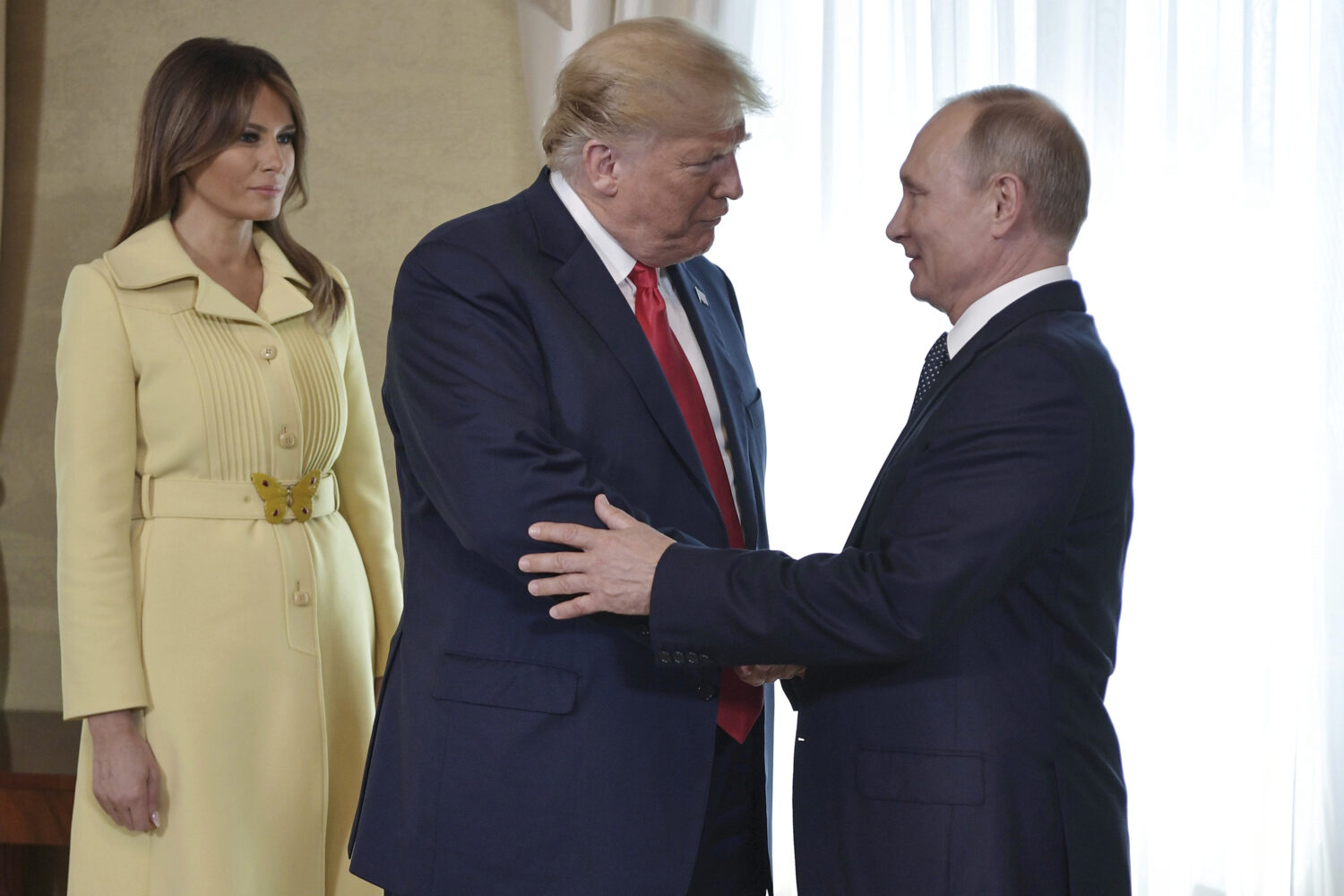FILE - First lady Melania Trump, left, watches as President Donald Trump and Russian President Vlad...