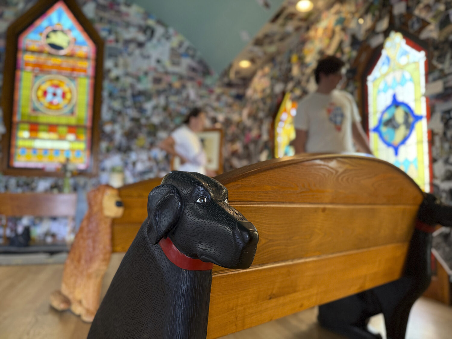 A black lab carved into a wooden pew is pictured in the Dog Chapel at Dog Mountain, a 150-acre dog ...