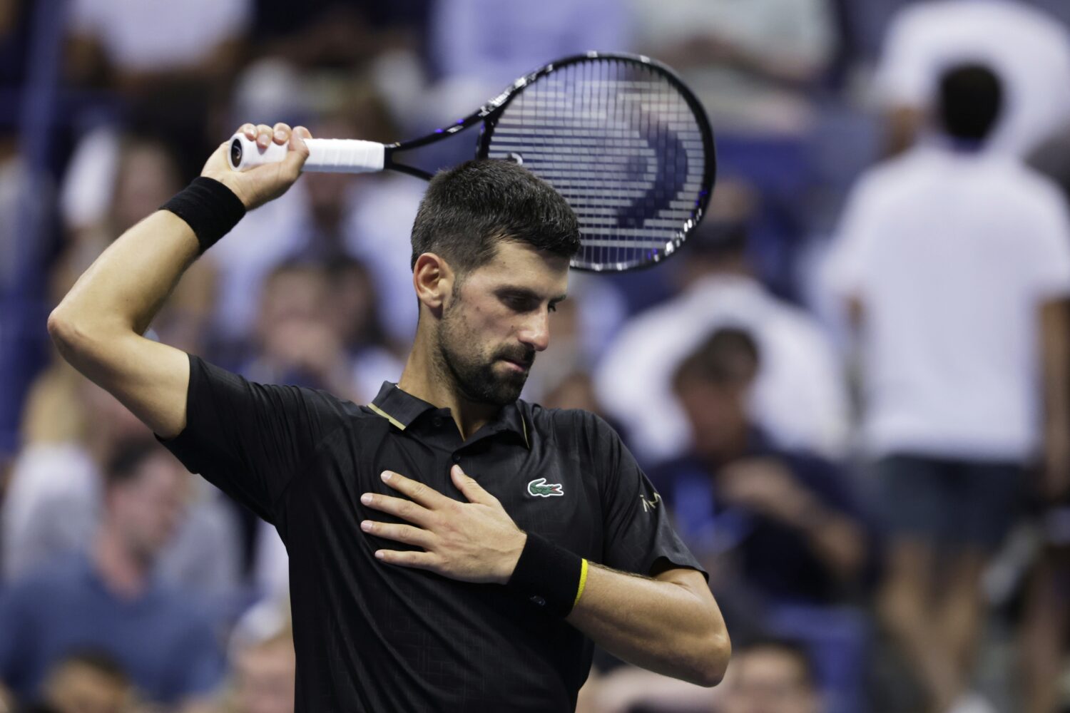 Novak Djokovic, of Serbia, stretches against Cameron Norrie, of Great Britain, during the third rou...