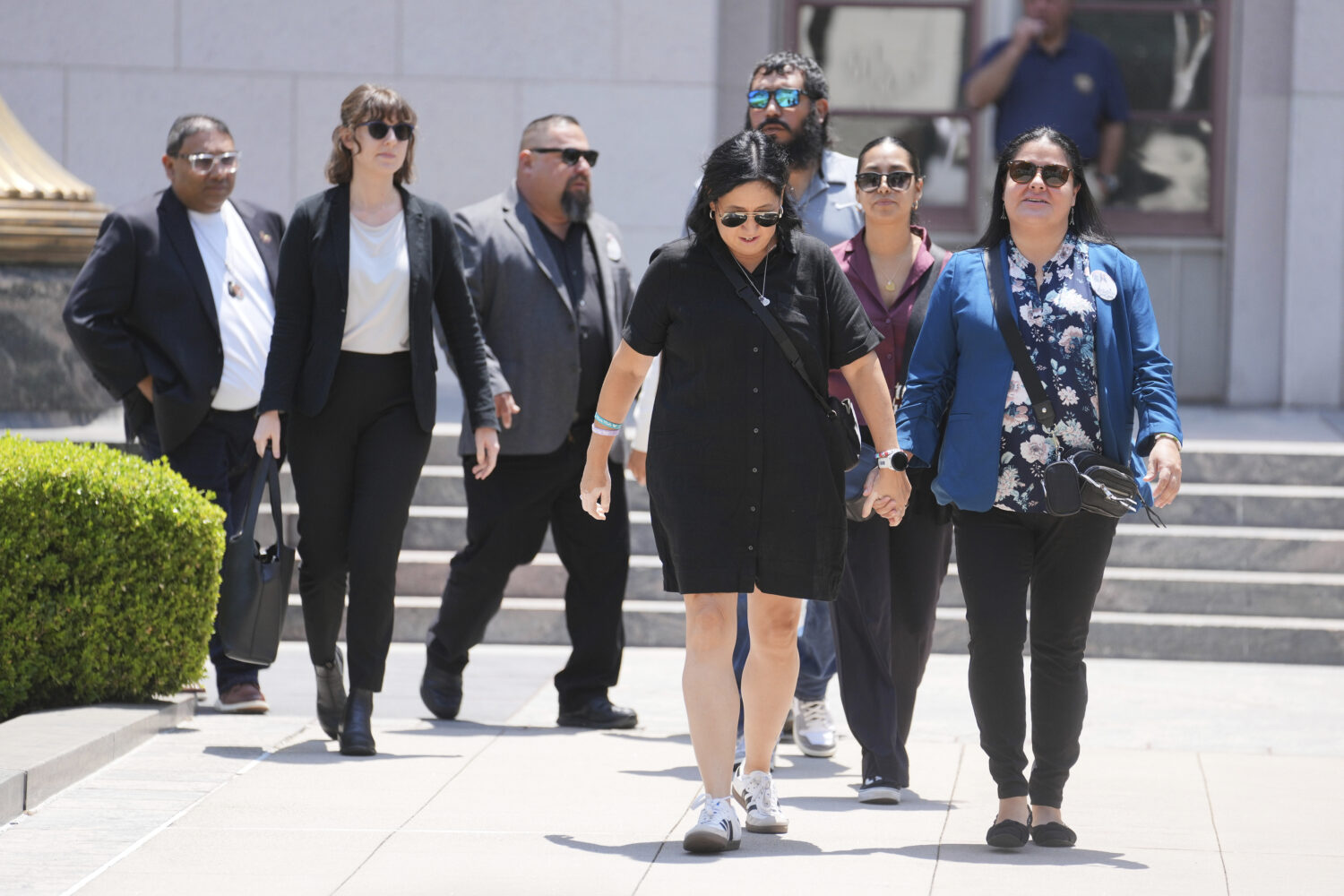Gloria Cazares, right, holds hands with Veronica Mata during a break in a court hearing in a lawsui...