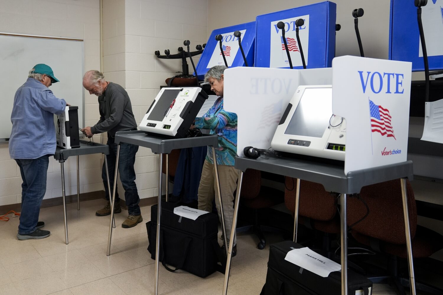 FILE - Poll workers set up ballot-marking machines at an early in-person voting site at Asheville-B...