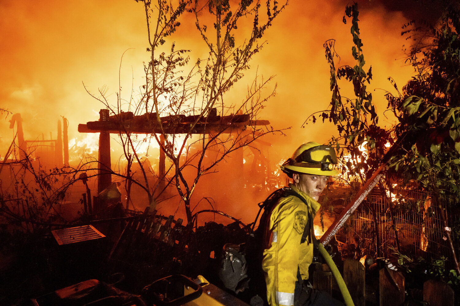 A firefighter battles the 6-5 Fire burning through the Chinese Camp community of Tuolumne County, C...