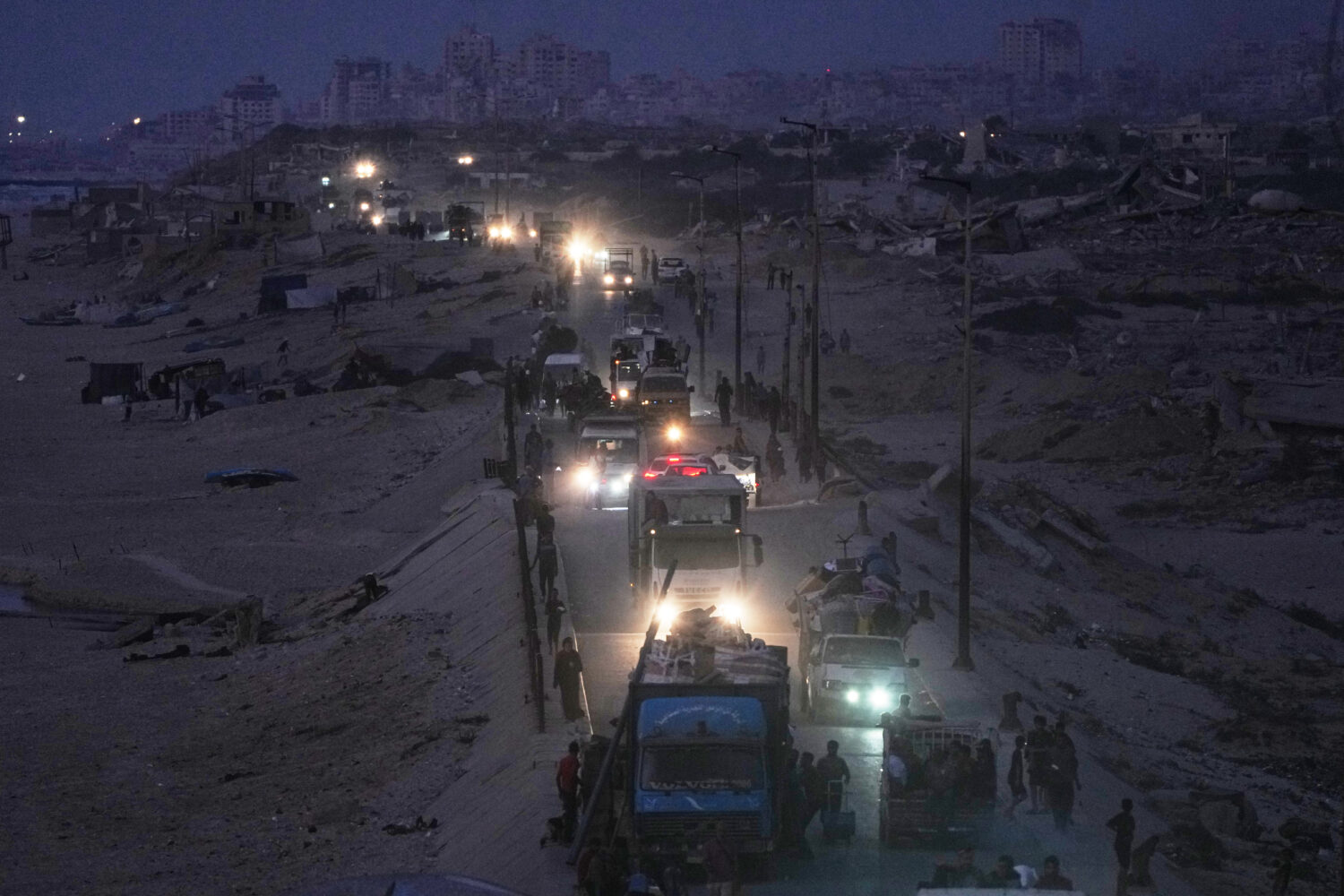 Displaced Palestinians flee northern Gaza, by vehicle and on foot, carrying their belongings along ...