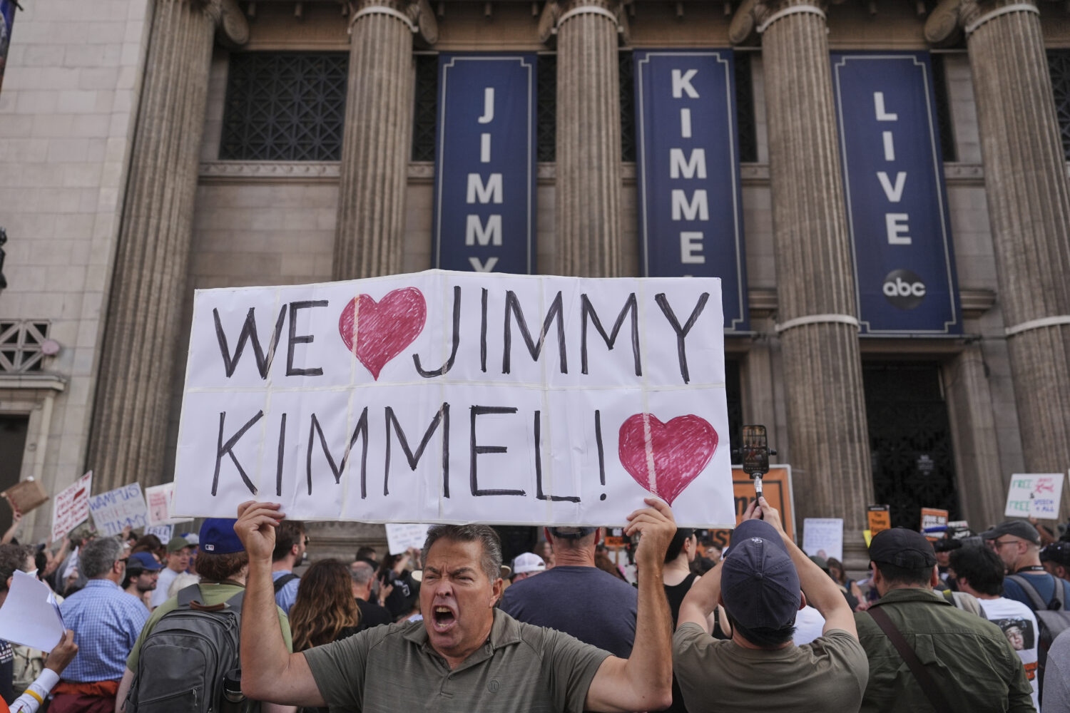 Oscar Villanueva holds a sign outside El Capitan Entertainment Centre, where the late-night show "J...