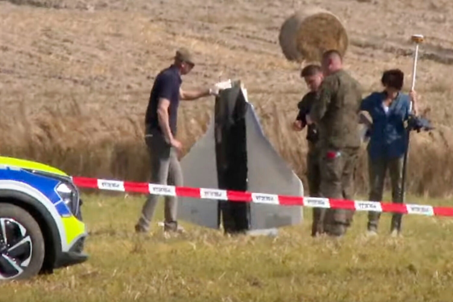 In this image made from video, Police and Military Police secure parts of a damaged object shot dow...