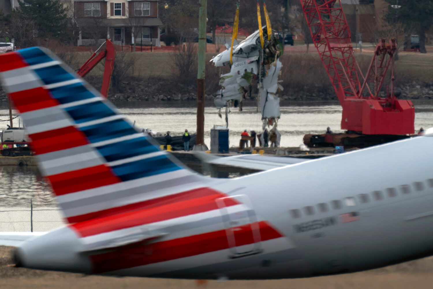 FILE - Crews pull up a part of a plane from the Potomac River near Ronald Reagan Washington Nationa...