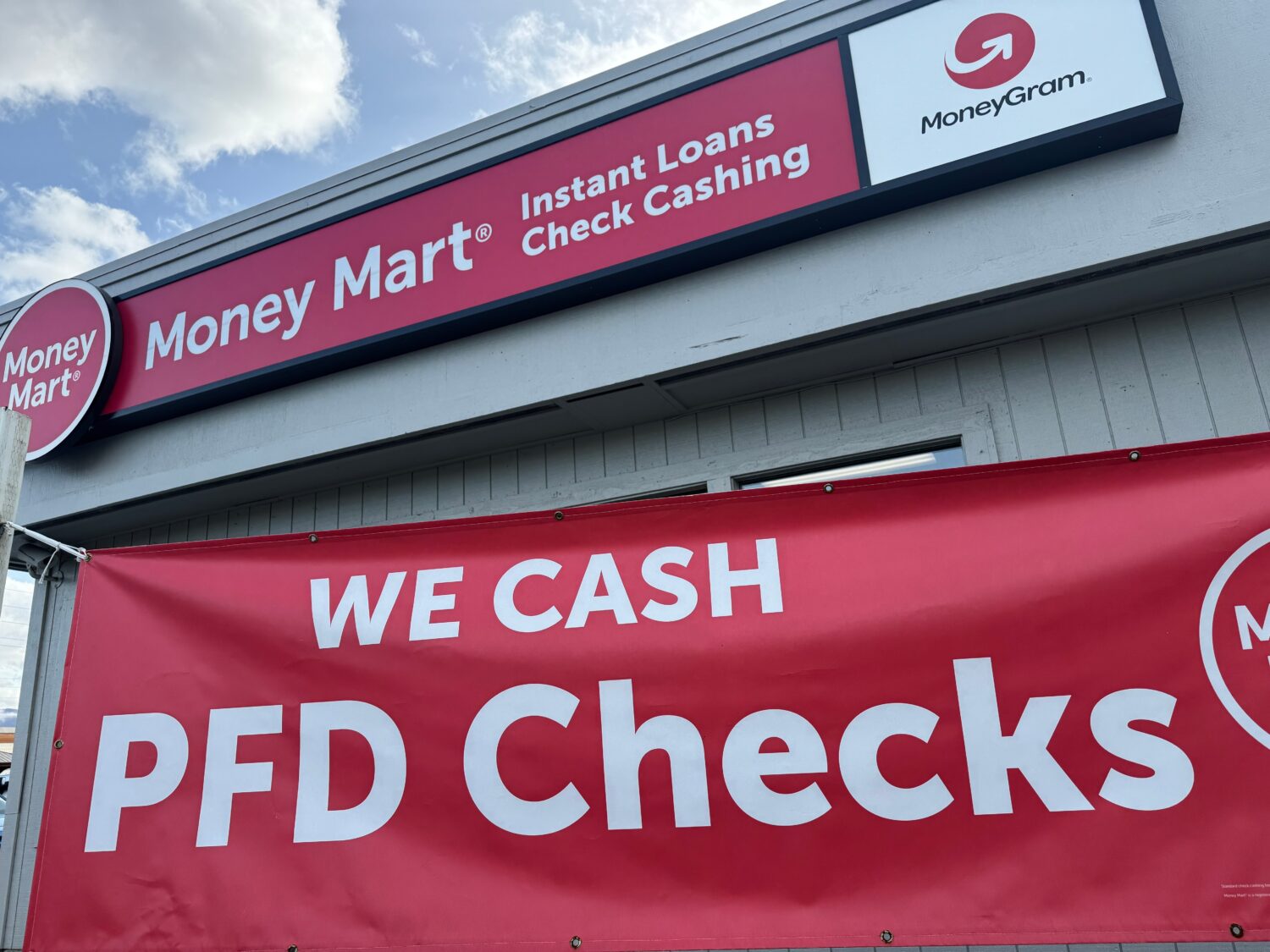 A sign advertising the cashing of Alaska Permanent Fund Dividend, or PFD, checks hangs outside a bu...