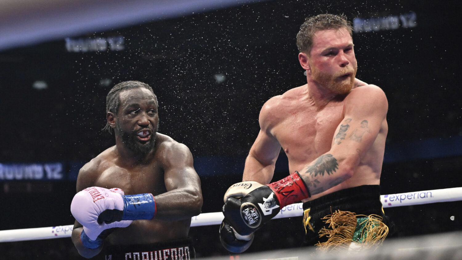 Terence Crawford, left, punches Canelo Alvarez during an undisputed super middleweight championship...
