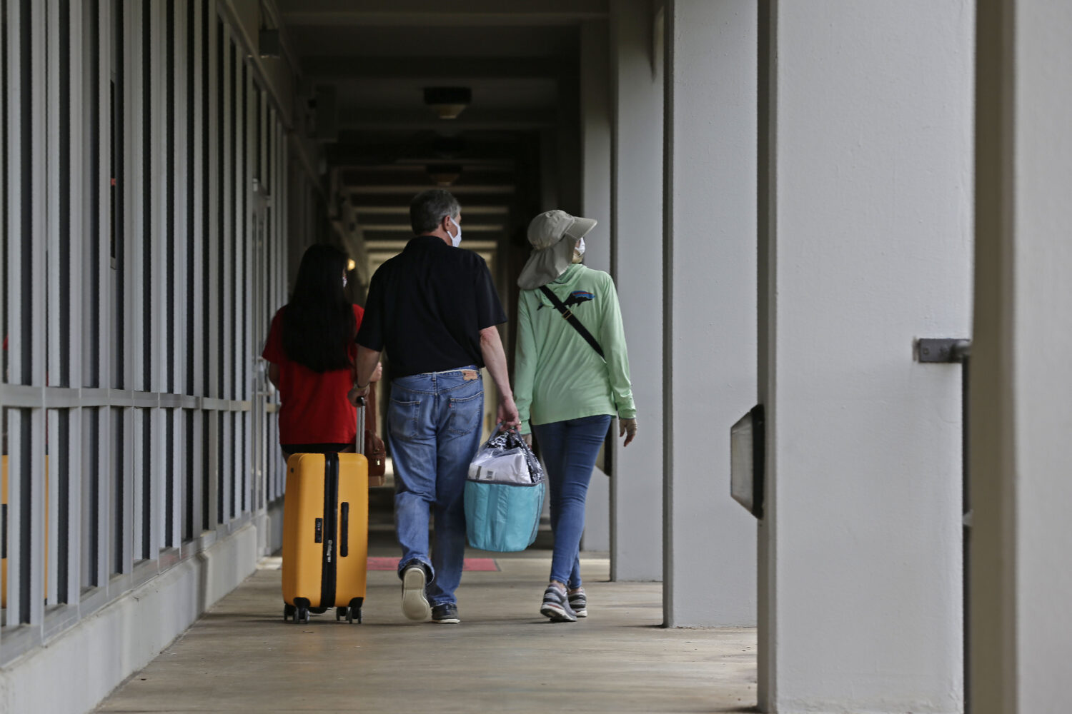 FILE - A family walks down a corridor at Lee Hall as college students begin moving in for the fall ...