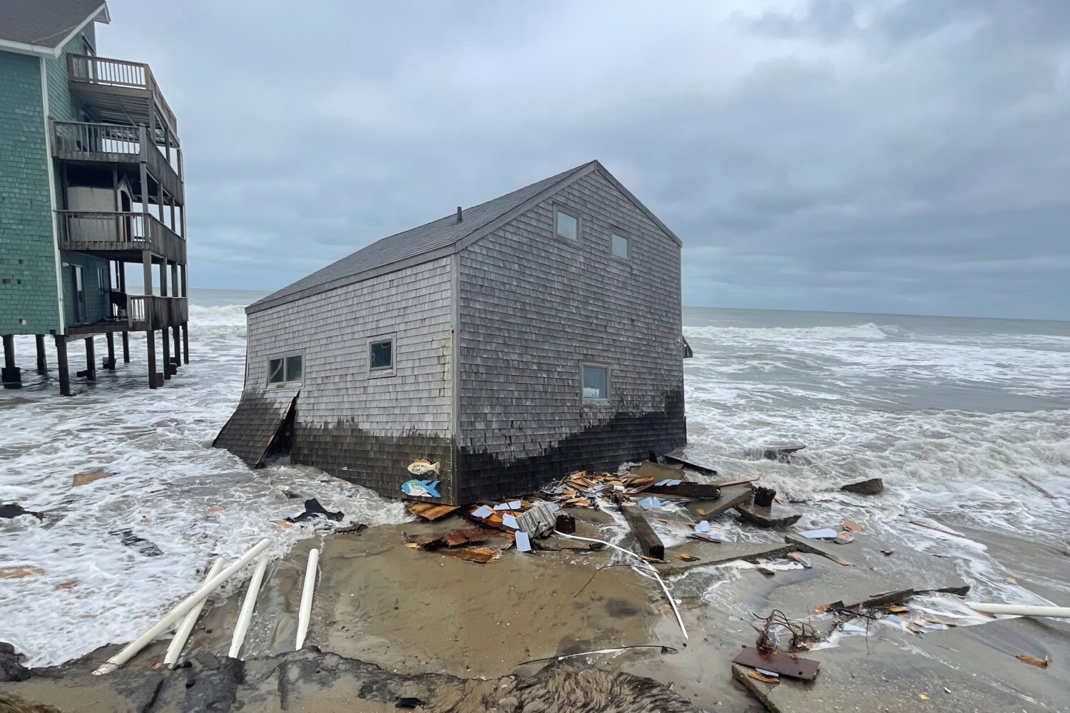 A collapsed beach cottage sits in waves on the shore Tuesday, Sept. 16, 2025, Buxton, NC. (Cape Hat...
