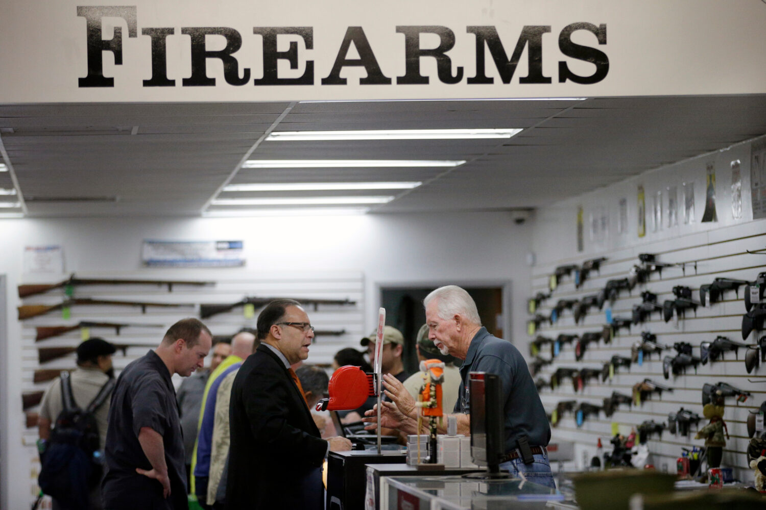 FILE - Sales associate Mike Conway, right, shows Paul Angulo guns at Bullseye Sport gun shop in Riv...