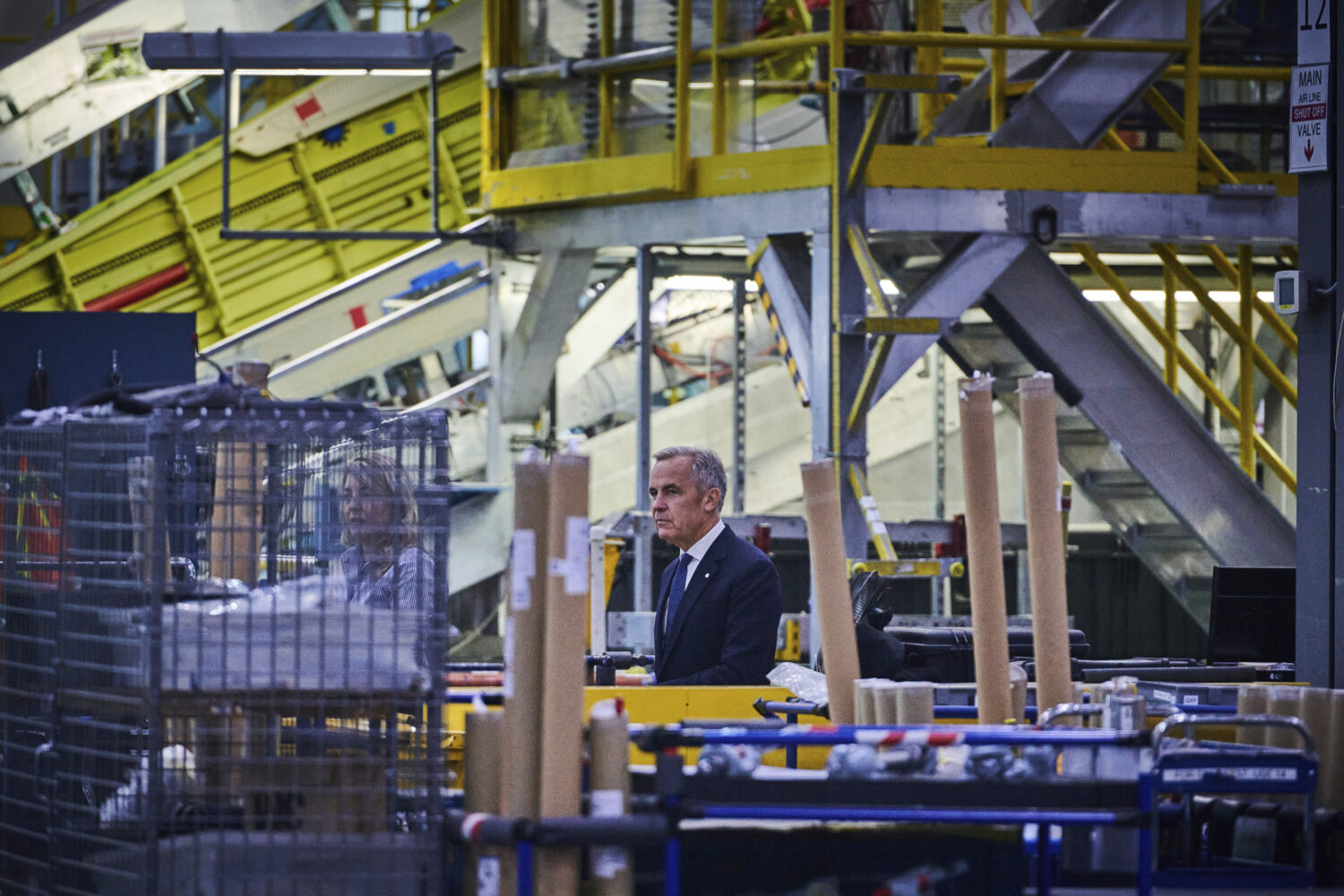 Prime Minister Mark Carney walks through a manufacturing facility ahead of a press conference in Mi...
