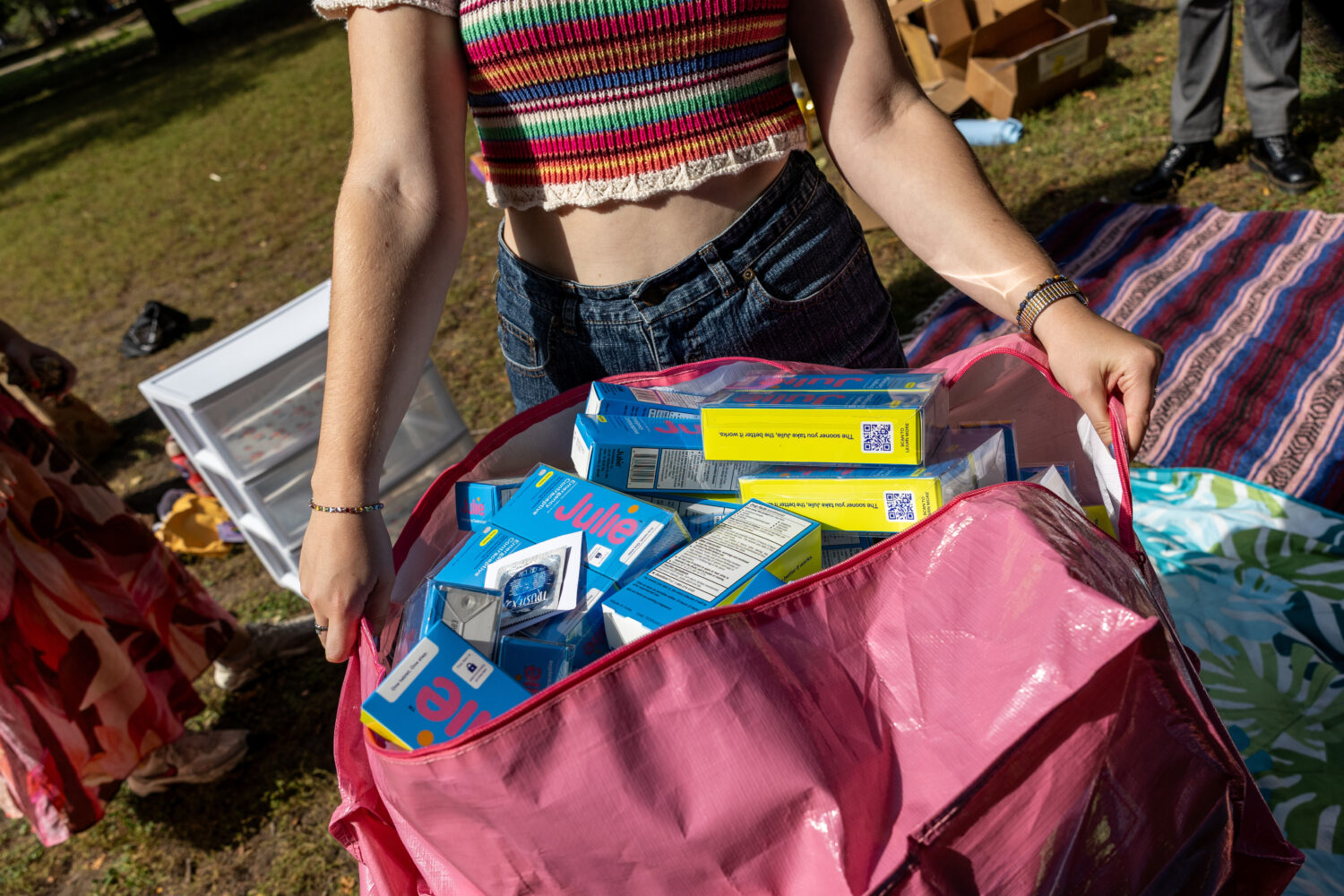 A DePaul University student carries a bag of contraceptive supplies at Oz Park in Chicago on Sunday...