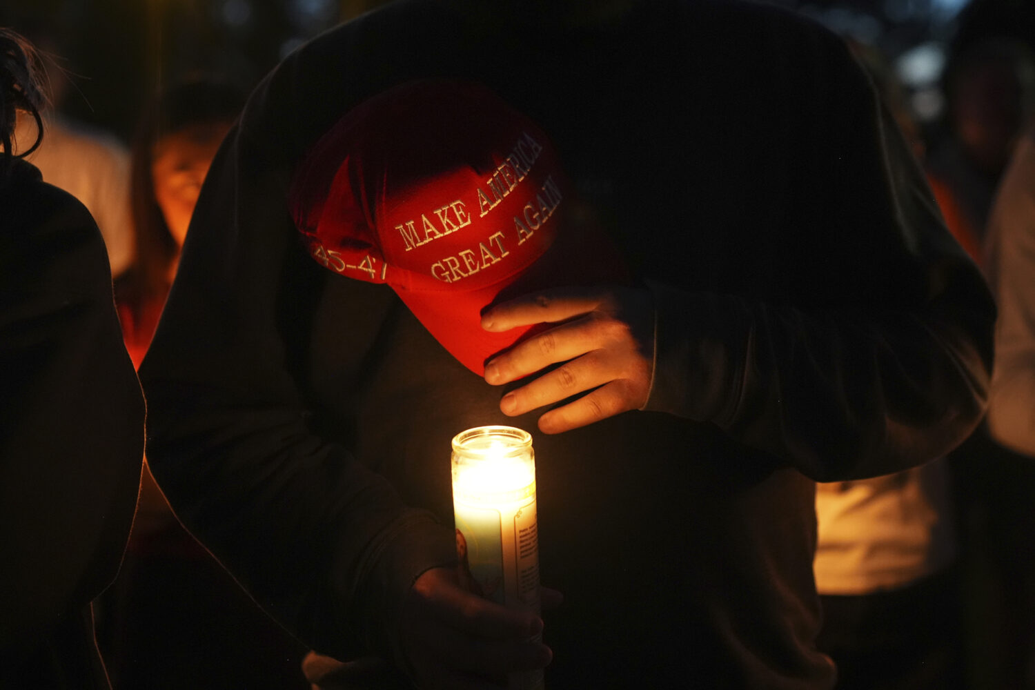 Alex Thomson holds a "Make America Great Again" hat during a vigil for Charlie Kirk on Friday, Sept...