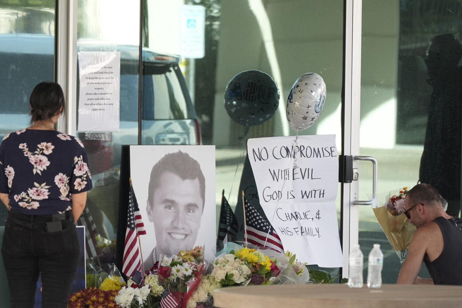 Well-wishers pay their respects at a makeshift memorial at the national headquarters of Turning Poi...