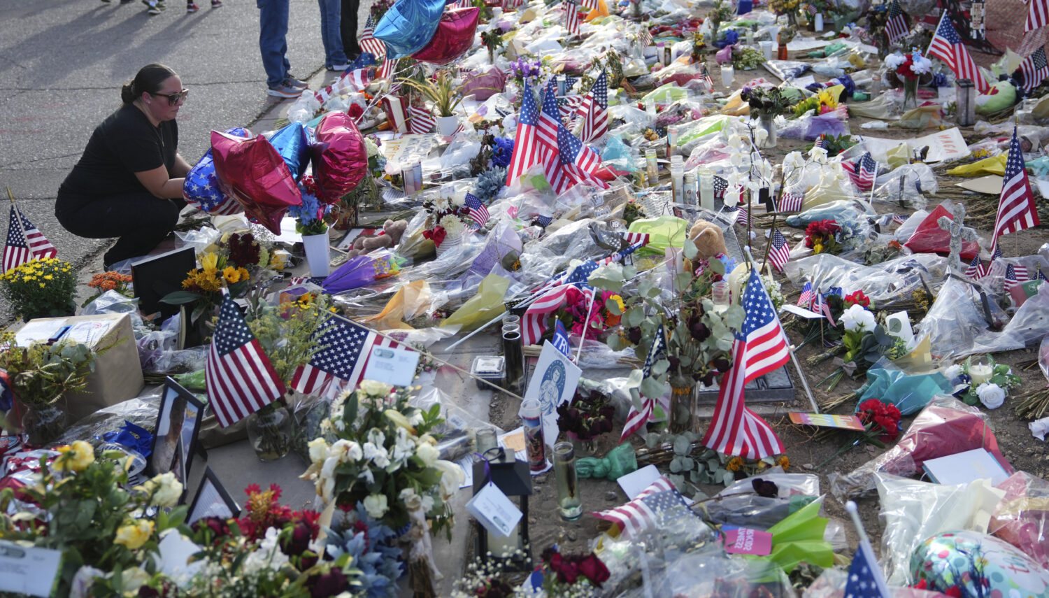A well-wisher pauses at a growing makeshift memorial set up at the Turning Point USA headquarters a...