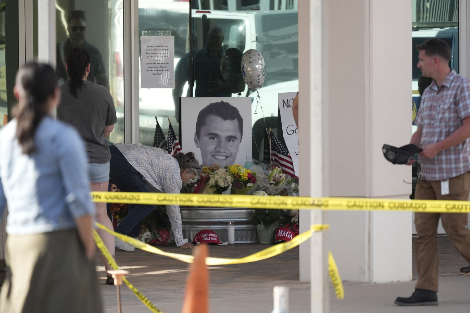 Well-wishers pay their respects at a makeshift memorial at the national headquarters of Turning Poi...