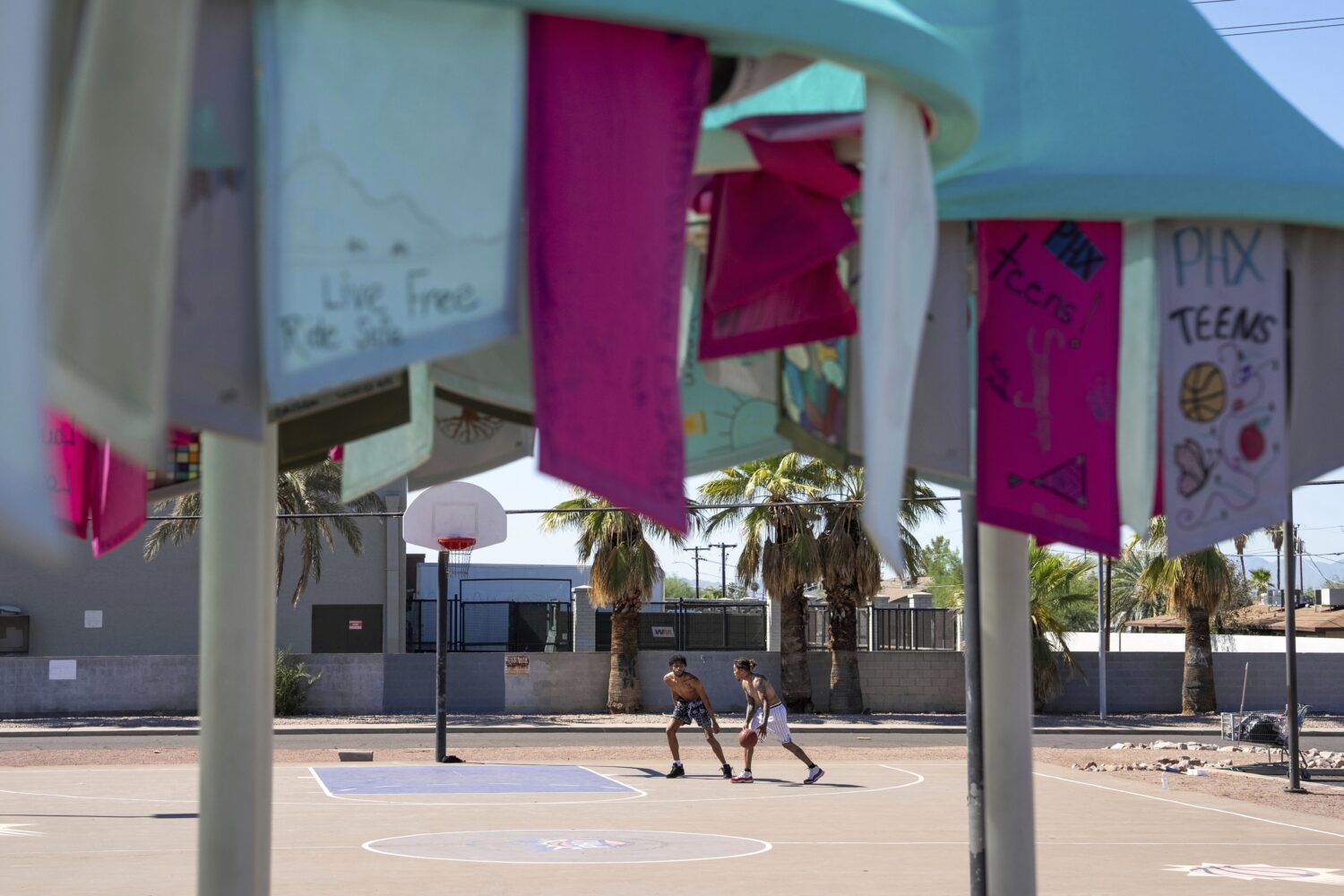 Edward Shephard, left, and Adrian Simpson play basketball near a temporary public art piece that pr...