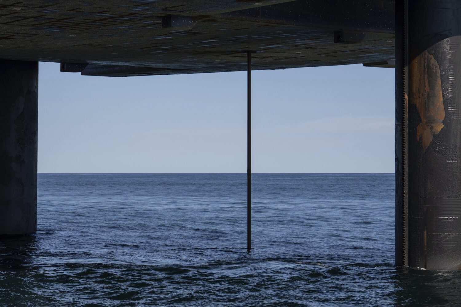 The wireline drilling core barrel is visible from the underside of the Liftboat Robert platform, fr...