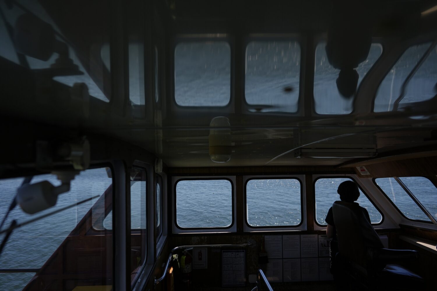 Expedition 501 member Verena Heuer looks out from the bridge of the Gaspee, a crew transport vessel...