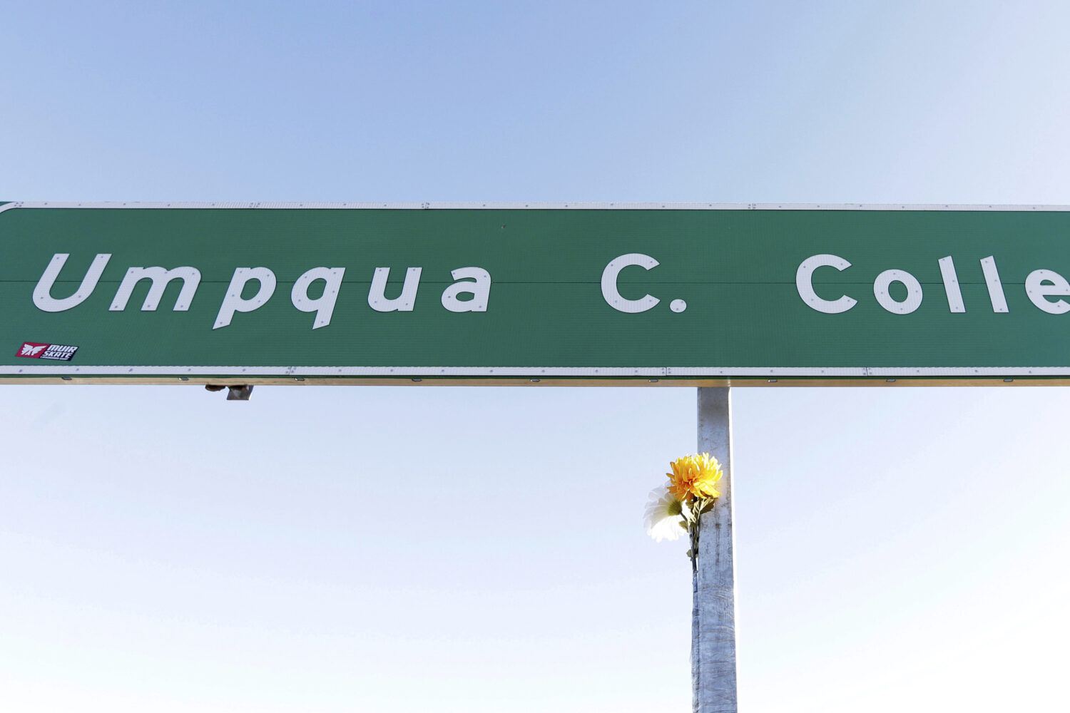 FILE - A flower is posted on a direction sign to Umpqua Community College, Oct. 2, 2015, in Rosebur...