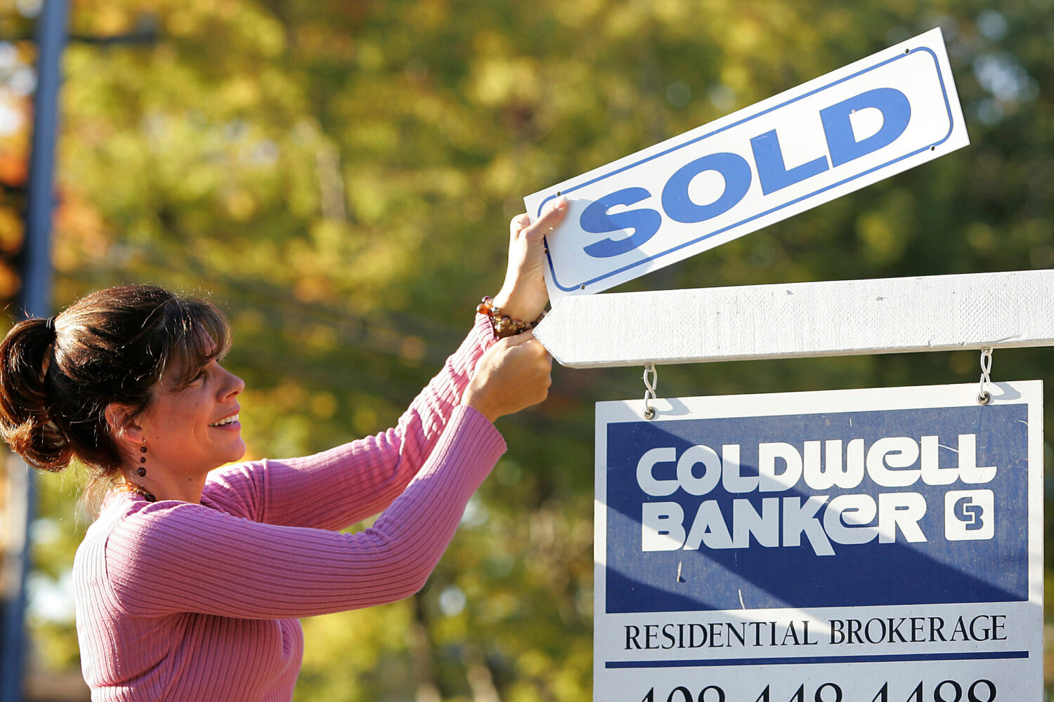 FILE - Coldwell Banker realtor Suzanne Hunter puts a sold sign on a home that she sold in Santa Cla...