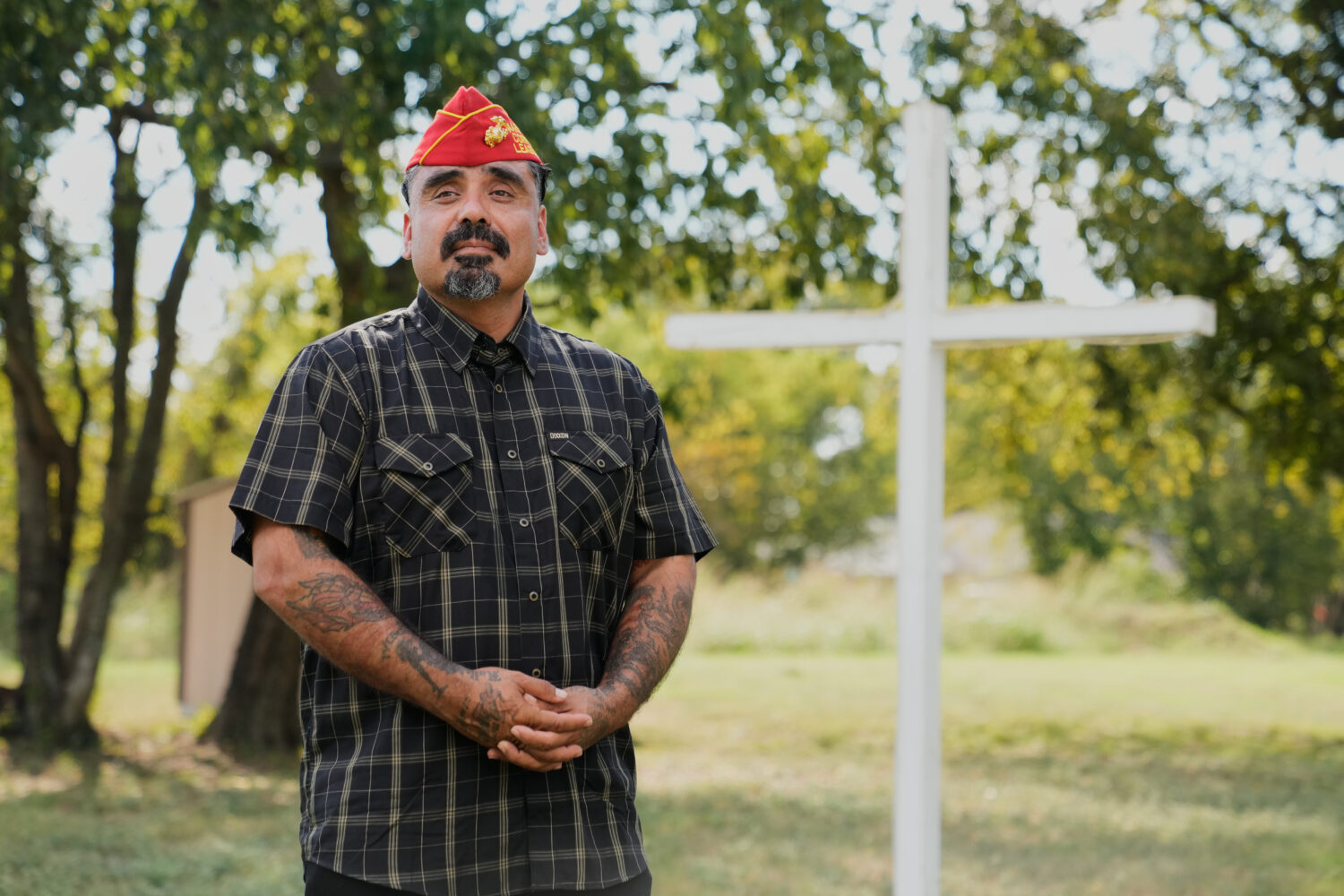 Julio Torres poses for a photo by a cross in an open field, Monday, Sept. 22, 2025, in Terrell, Tex...