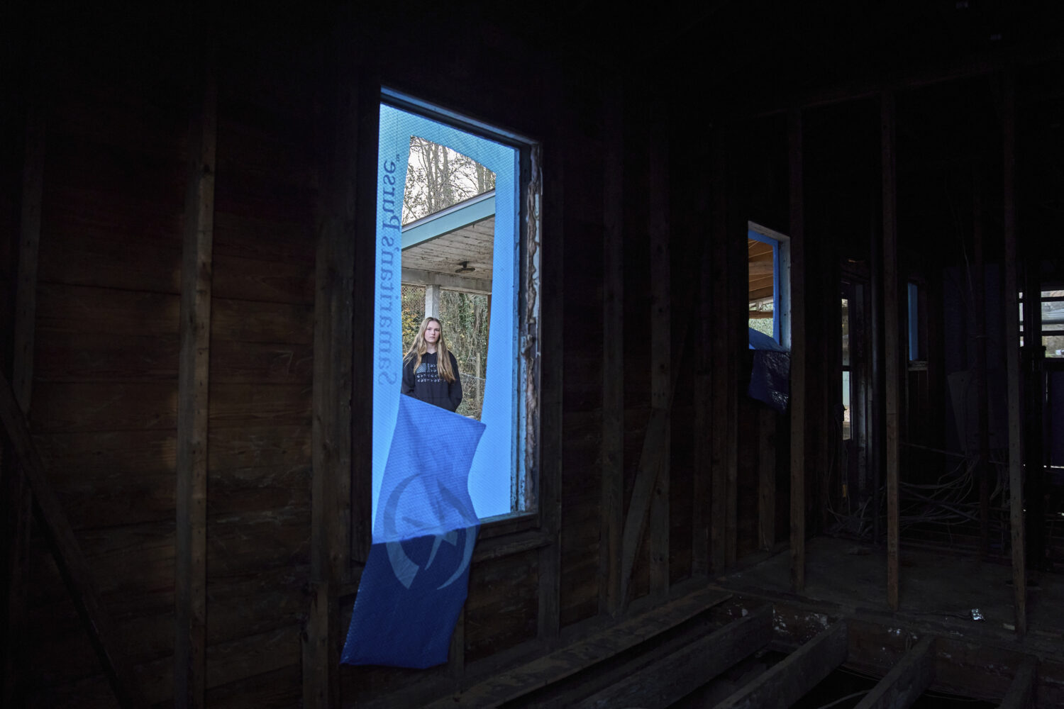 Natalie Briggs looks through a window of her home that was damaged during Hurricane Helene in Swann...