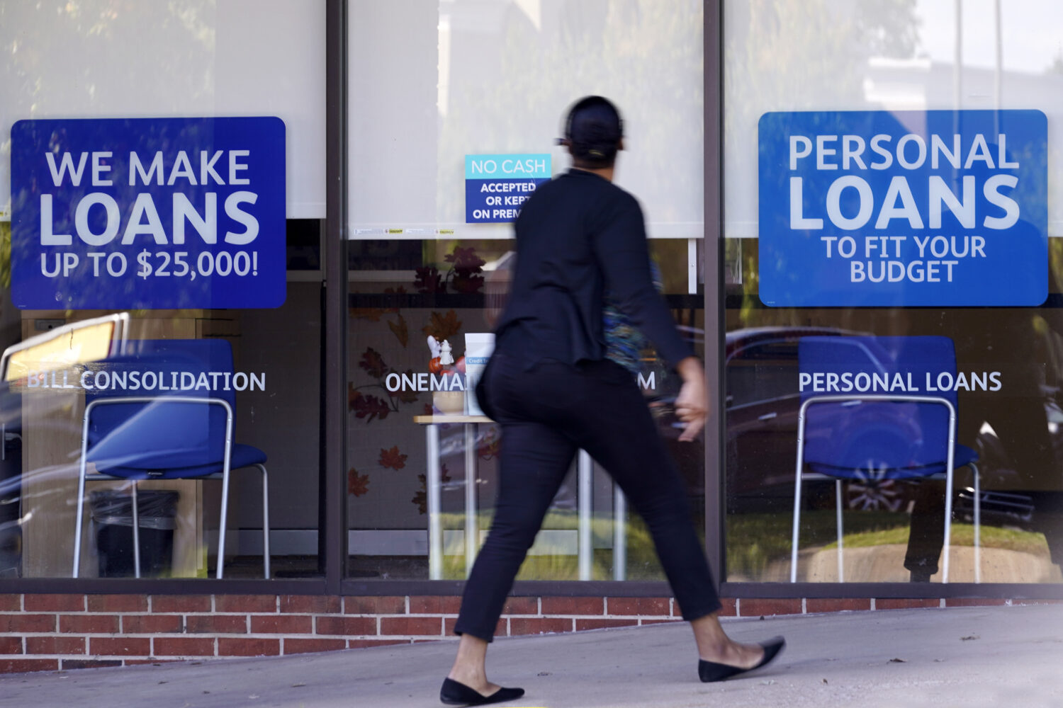 FILE - A woman walks past a personal finance loan office Thursday, Oct. 1, 2020, in Franklin, Tenn....