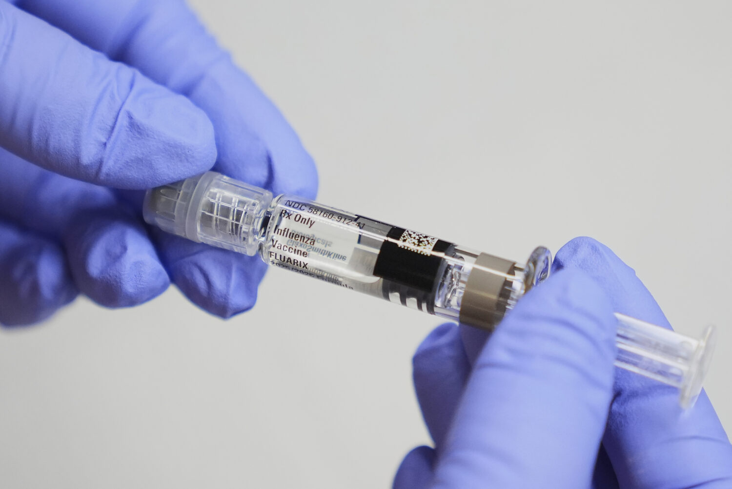Clinic support supervisor May Fengmei Lin, CMA, displays a syringe of the Fluarix flu vaccine at In...