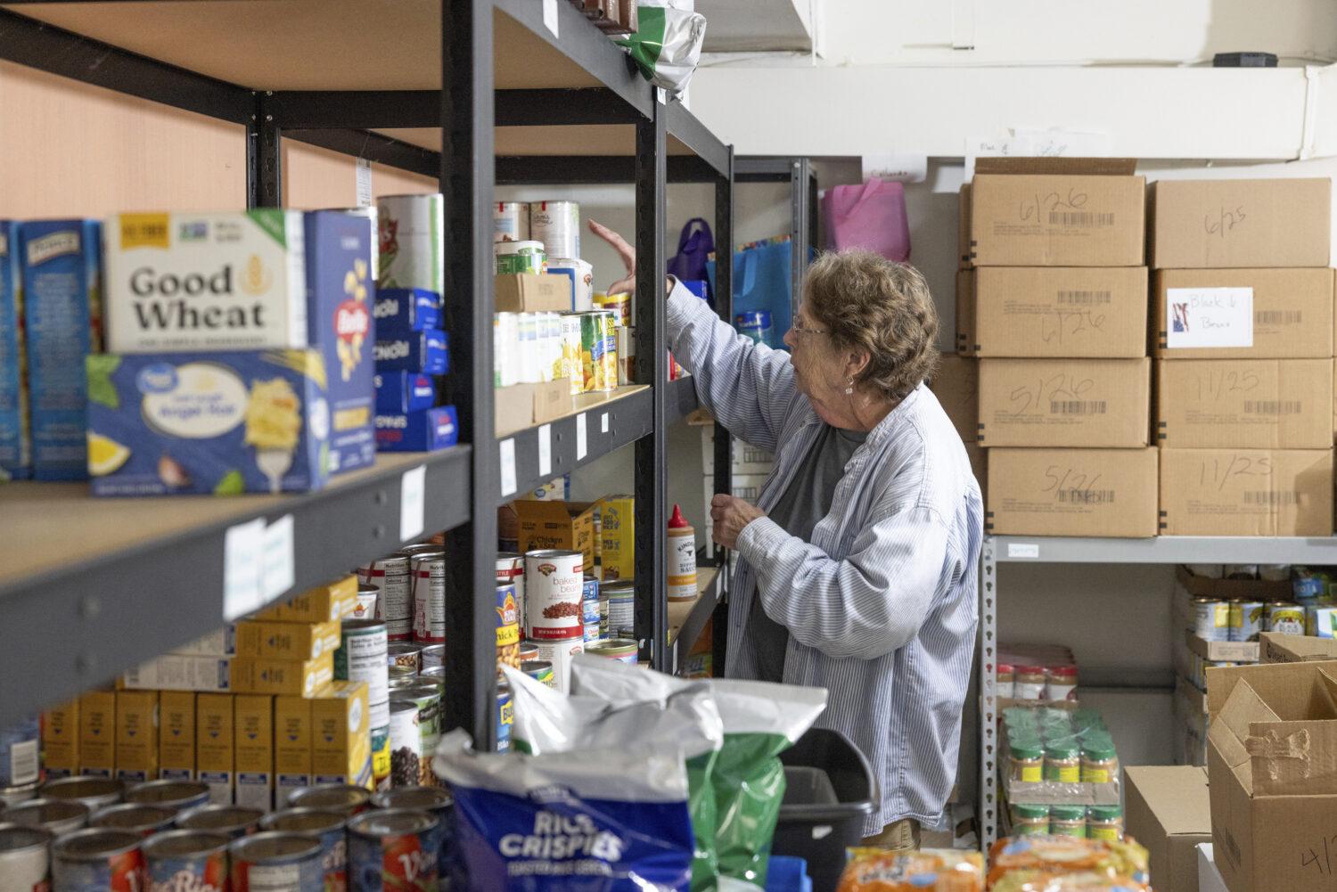 Phylis Allen organizes supplies at Neighbor's Cupboard in Winterport, Maine, on Tuesday, Aug. 26, 2...