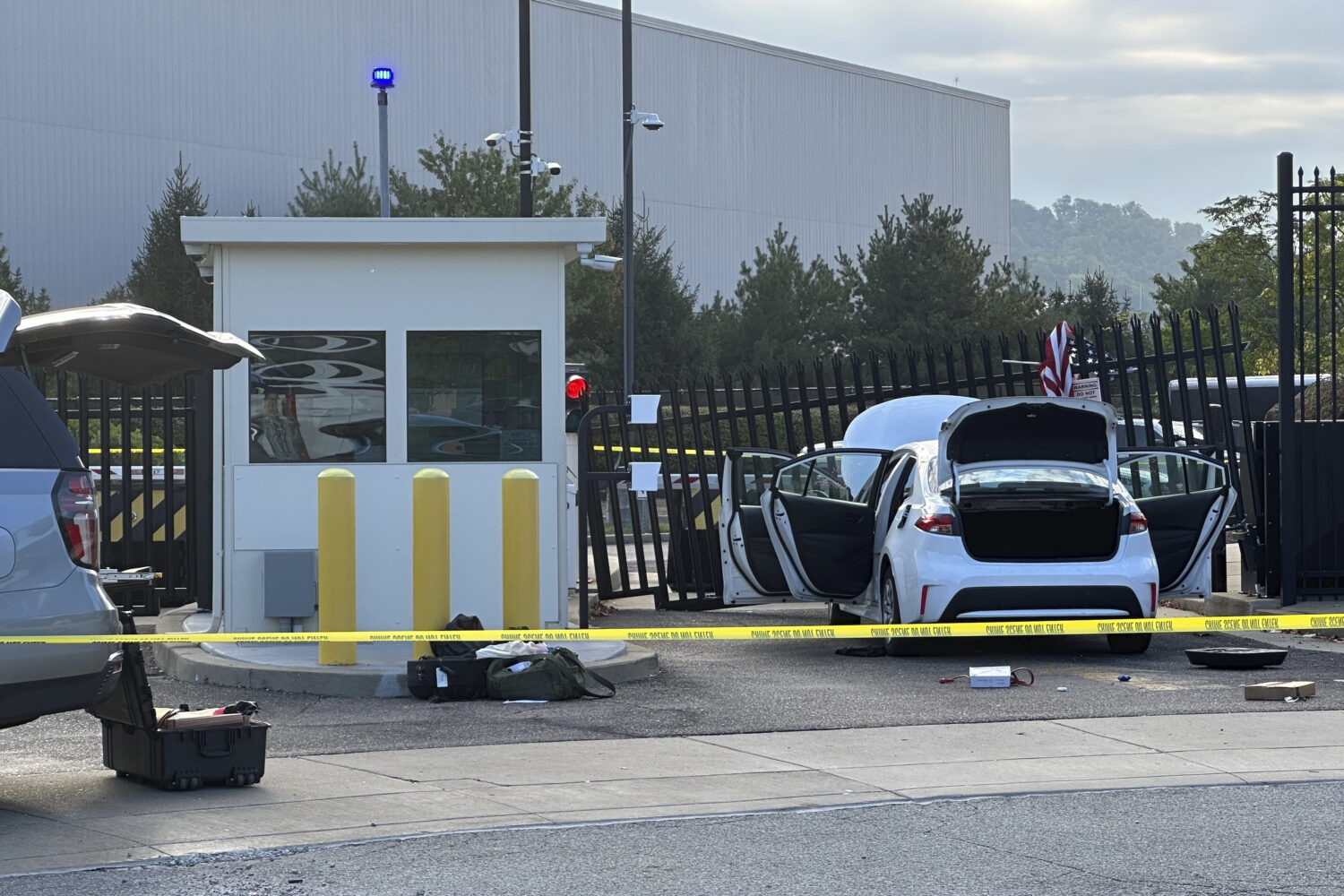 FBI officials inspect a car that rammed into a gate at the FBI building in Pittsburgh, Wednesday, S...