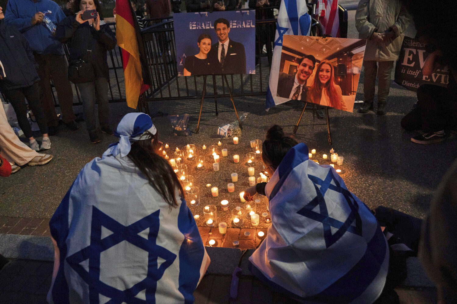 FILE - People gather to light candles in a makeshift memorial to honor Yaron Lischinsky and Sarah M...