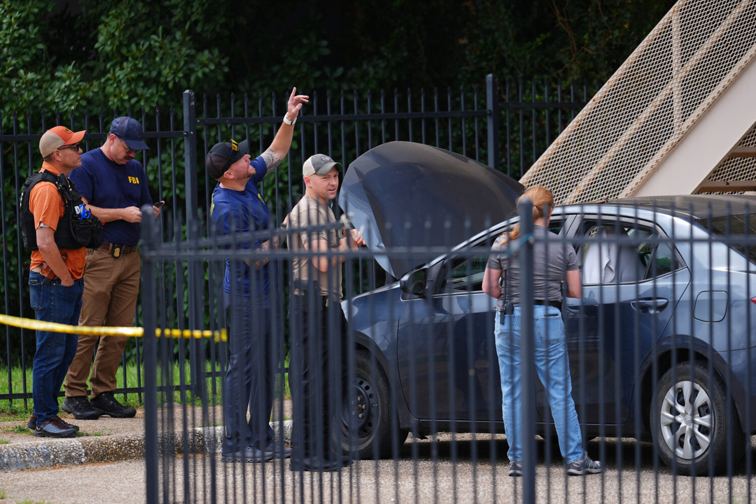 A law enforcement agents search a vehicle near the scene of a shooting at a U.S. Immigration and Cu...