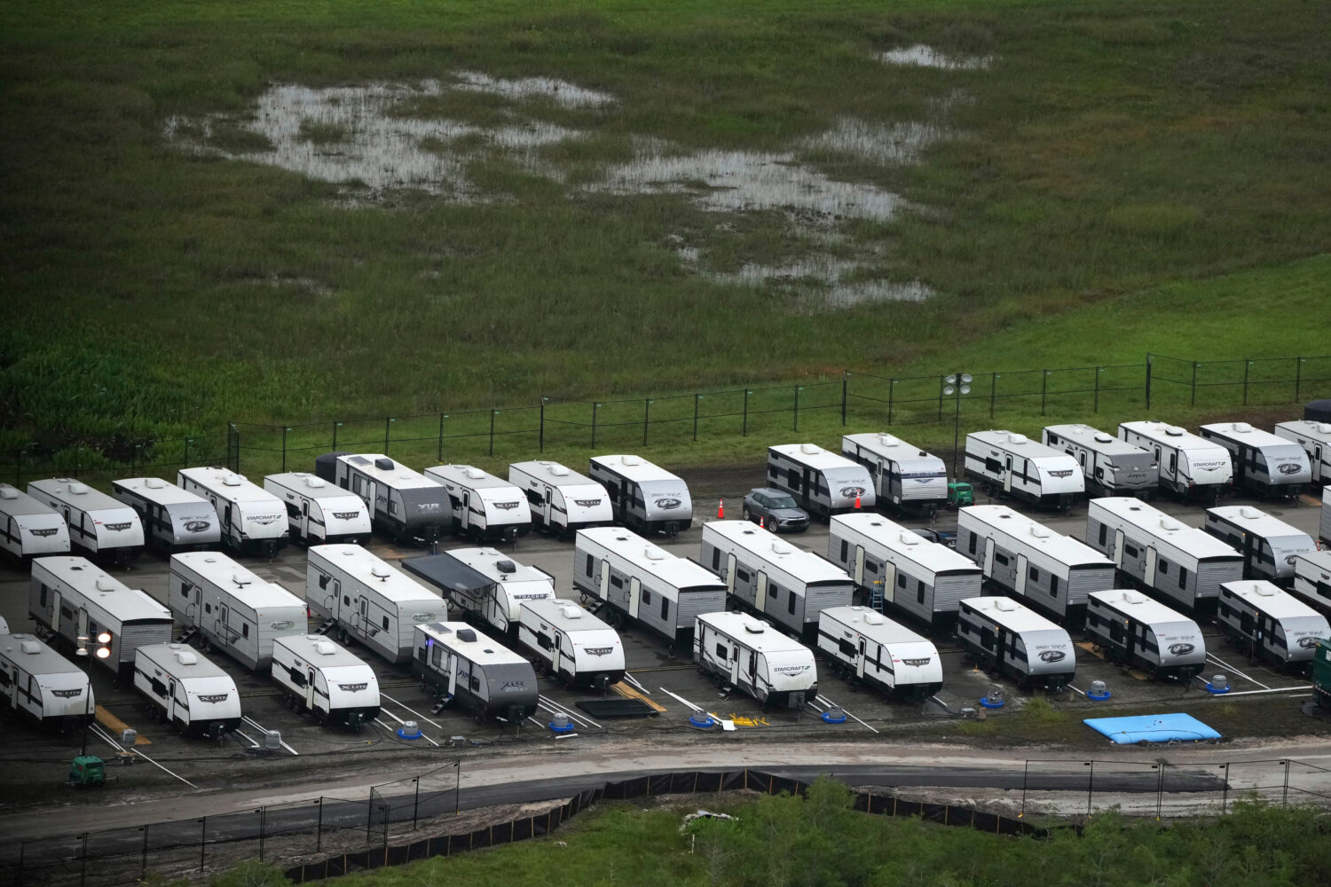 FILE - Trailers sit parked in lines as work progresses on a migrant detention center at Dade-Collie...