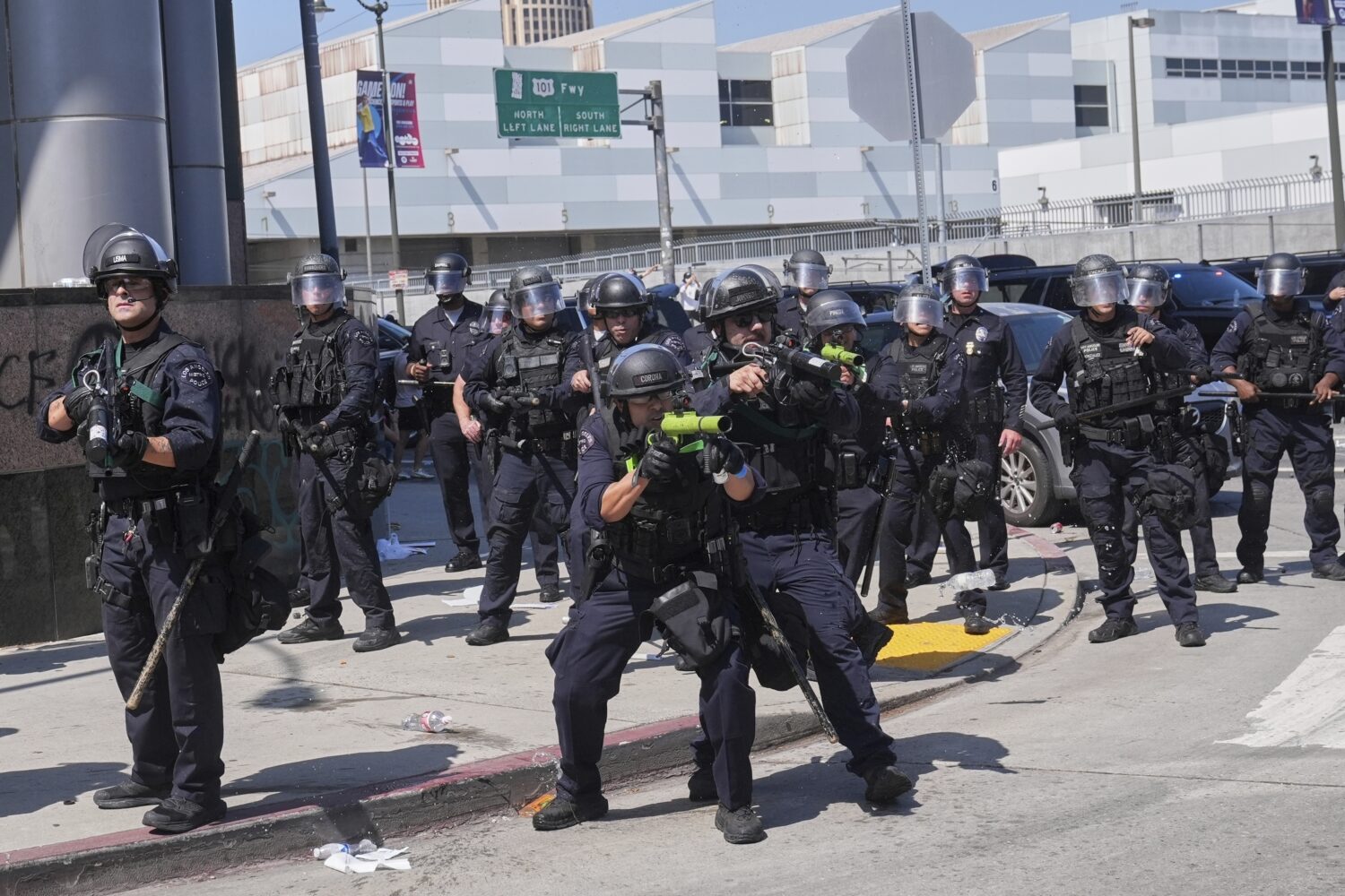 FILE - Police defend the Metropolitan Detention Center in downtown Los Angeles, June 8, 2025, follo...